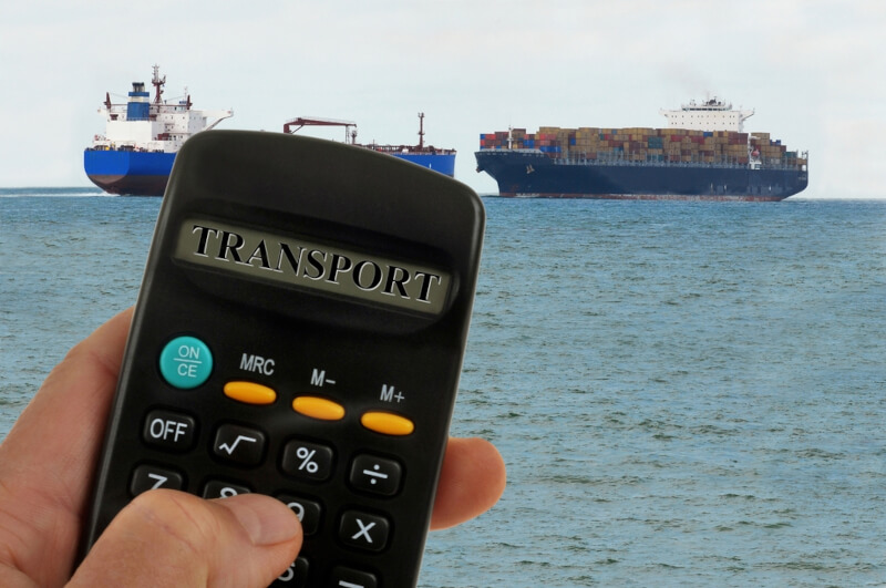 Kalkulator z napisem transport na tle dwóch kontenerowców - inrel.pl